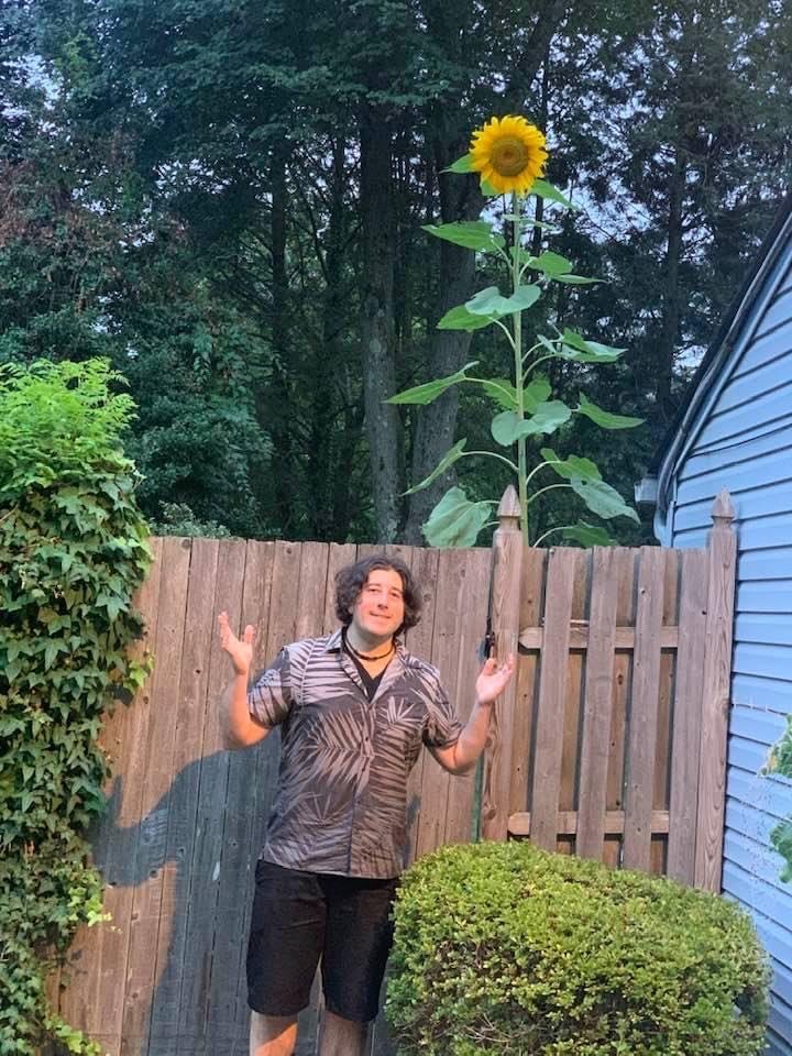 Lee shrugs with Bobbie's TALL sunflower.